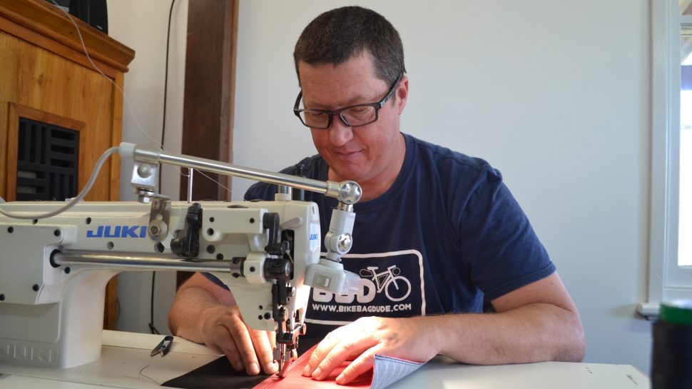 Kedan Griffin at the sewing machine sewing a custom bag