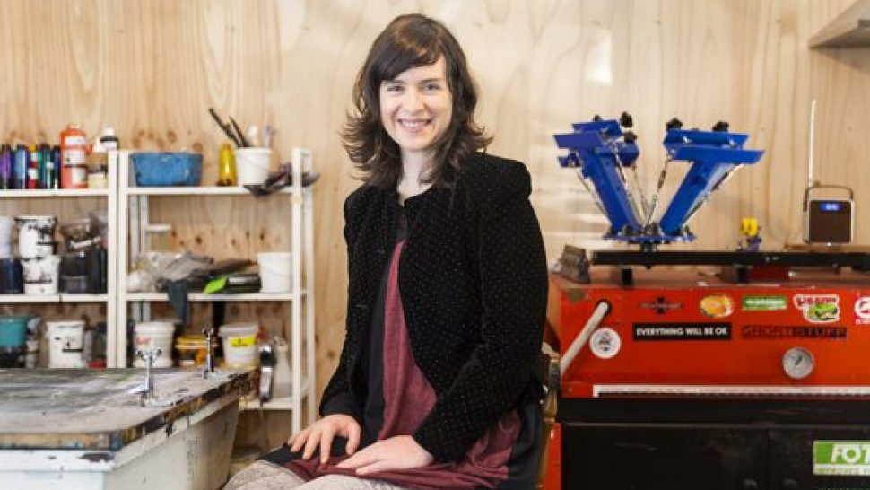 Katy, the owner of Captain Robbo, sitting in her design studio wearing a pair of Adventure Pants. 