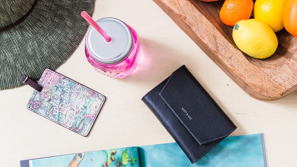 Flatlay photograph of a hat, a timber fruit bowl, a wallet, a reusable drink bottle and a magazine